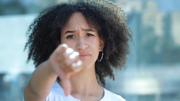 年轻美丽的非洲裔美国女人伸出手来，用大拇指放下沮丧和厌恶的手势。女孩表达了她真正的负面情绪，不以为然地看了看，摇着头说："不。. — 图库视频影像