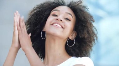 Güzel Afrikalı Amerikalı kız ellerini çırpıyor, dişlek bir şekilde gülümsüyor ve vay canına diyor. Genç bir kadın şaşırmış ve mutlu. Onayını ve hayranlığını ifade ediyor. Alkışlıyor. Samimi duygular ve duygular kavramı.