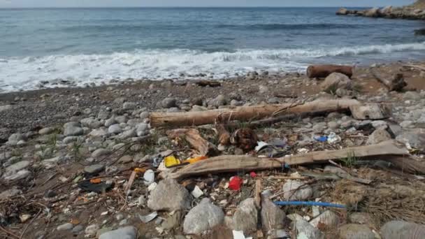汚染された海岸の海。人類の地球規模の問題地球ゴミ、人々による環境汚染。土地の目詰まりの生態学的悲劇。海の上の埋め立て、自然の波によって投げられたプラスチック破片をダンプ — ストック動画