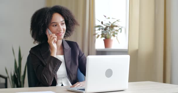 Ung vänlig affärskvinna konsult bär kavaj, sitter i mysiga kontor hemma, prata på mobiltelefon linje, tala förhandla, diskutera med människor, svara positivt — Stockvideo