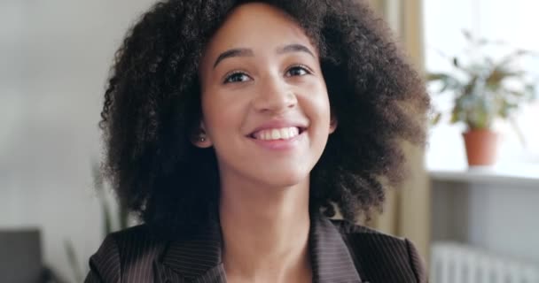 Head shot studie portræt af tilfreds glad krøllet pige, teenager afrikansk etnicitet med toothy perfekt smil griner oprigtigt muntert, nyder livet og ser på kamera venlige flirter ansigt – Stock-video
