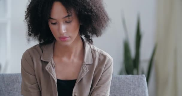 Shocked mixed race woman entrepreneur sits in room, reads debt bankruptcy note, learns about crisis, money problems. Upset girl feeling sad, holding non-payment notice, worried person face close up — Stock Video