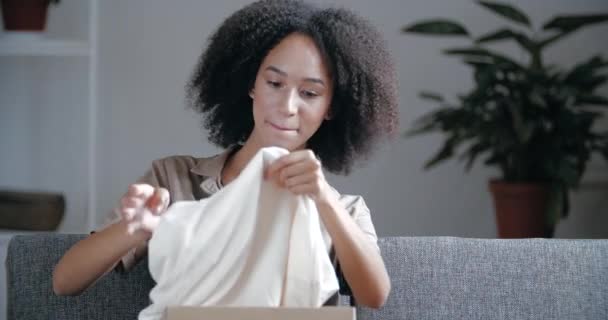 Cliente feliz mulher satisfield cliente recebe caixa de papelão abre pacote encomendar roupas elegantes camiseta branca para o serviço de entrega em domicílio, tempo de quarentena, conceito de compras na internet — Vídeo de Stock