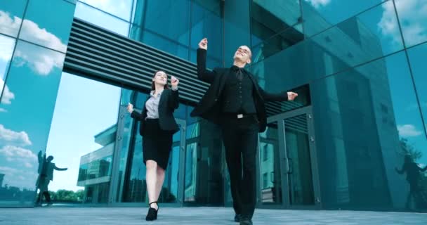 Pair serious man and woman students going dancing in black costumes, celebrating victory triumph. Two young business person, lawyers win case contract, circling moving happily, fly paper documents — Stock Video