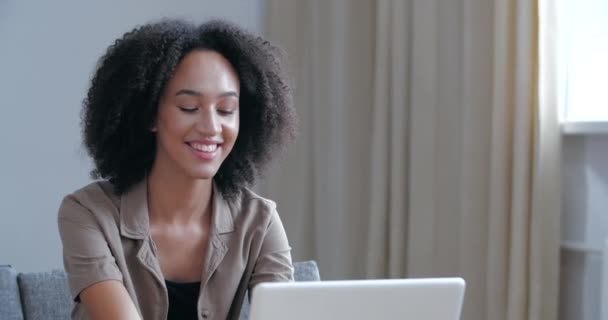 Attraktive junge Afro-Mädchen sitzen mit Laptop tippen lächelt in die Kamera zeigt Hand OK Zeichen, zustimmen Symbol. Amerikanische Studenten lernen online zeigt alles feine Erfolgsgeste Körpersprache aus nächster Nähe — Stockvideo