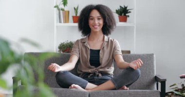 Genç etnik kız evde sabah nefes egzersizleri yapıyor, rahat koltukta yoga yapıyor, Asana Lotus insan vücudunda oturuyor, dinlenme sükunetini bozuyor, mutlu enerji uyum kavramını hissediyor.