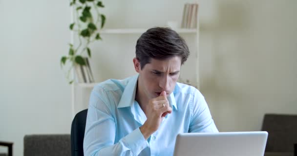 Portrait d'un homme lourd et sérieux assis au bureau, utilisant un ordinateur portable pour résoudre un problème, rechercher des informations. Gros plan homme d'affaires pensant se rappeler, frotter son temple, prendre des notes, concept de prise de décision — Video