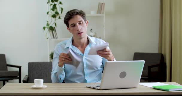 Geschäftsmann, der unter Sommerhitze im Büro zu Hause leidet, sitzt in stickigem Raum. Genervter erschöpfter Arbeiter frischt sich mit Notizbüchern mit Papierdokumenten auf, Probleme mit der Klimaanlage — Stockvideo