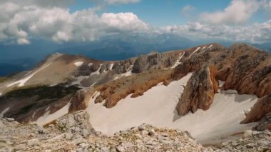 Rusya, Adygea Cumhuriyeti 'ndeki Kafkasya' daki büyük dağların siluetlerine karla kaplı olağandışı kahverengi dağın üzerinden uçmak. Aktif seyahat ve doğa yürüyüşü kavramı.