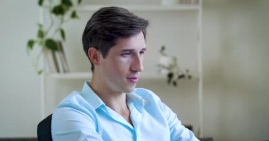 Portre yakışıklı CEO yöneticisi kendinden emin, iş adamı gömlekli, dost canlısı bir şekilde kameraya bakıyor, başını sallıyor. Gülümseyen zarif, zarif erkek ofiste çalışıyor, yüzünü kapatıyor.