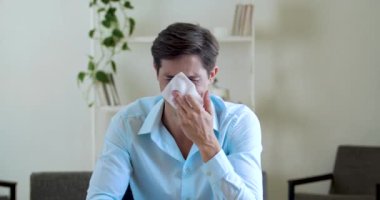 Yetişkin, çekici, üzgün iş adamı stresli, hıçkıra hıçkıra ağlıyor, burnunu mendille siliyor, keder duygularını kapatıyor. Ofis çalışanı erkek komik bir şekilde masada oturuyor.