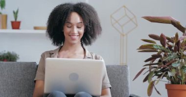 Genç Afrikalı Amerikalı serbest çalışan, uzaktan çalışan, bilgisayarını kullanarak diğer müşterilerle iletişim kuran, destek veren, video konferansına cevap veren, işaret gibi,