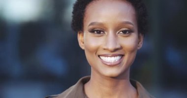 Güzel Afro-Amerikan etnik kadın portresi kameraya bakıyor, gülümseyen dişli, mutlu gözler, kısa saç, dost canlısı kadın yüzü. Caddede dikilen, kendini rahat hisseden melez kadının yakınına.