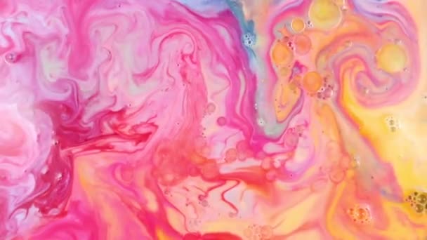 Close-up view of infusion of yellow paint in pink-blue paint in white milk. Vivid color mixing of multi-colored spots. Pink-yellow texture. Abstract art mixing paints in solution on white background. — Stock Video