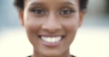 Afrika kökenli, Amerikalı, kendine güvenen, kısa saçlı, bin yıllık, kırışık, beyaz dişleri olan ve kameraya bakan genç, kendine güvenen bir kadının bulanık, belirsiz portresini kapat.