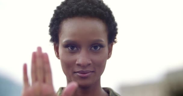 Portret zdecydowanej mieszanej dziewczyny rasy trzymającej dłoń przed sobą, z pewnością pokazującej hamujący gest zatrzymania się i braku działania. Młoda Afroamerykanka stanowczo trzymająca się z daleka demonstruje dystans — Wideo stockowe