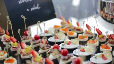 Düğündeki misafirler için şiş şiş üzerinde sabahları ziyafet salonunun siyah masasında uzanan çeşitli lezzetli aperatiflerin yanında çekim yapmak. Ana yemeğin önünde nefis mezeler..