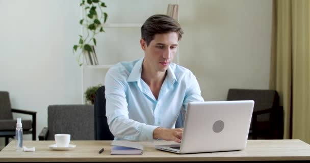 Σοβαρός συγκεντρωμένος επιχειρηματίας τύπος ηγέτη στο πληκτρολόγιο laptop, κοιτάζει την οθόνη του υπολογιστή, κάνοντας σημείωση στο σημειωματάριο. Φοιτητής που κάθεται στο σπίτι σε απευθείας σύνδεση εκπαίδευση εξ αποστάσεως από το δίκτυο internet — Αρχείο Βίντεο