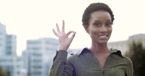 Dość młody etniczny Amerykanin krótkie włosy dziewczyna uśmiecha przyjazny patrząc w kamerę, pokazując ok gest. Kobieta składa palce do pierścienia, symbol wsparcia pokazuje doskonały doskonale normalny znak ręcznie — Wideo stockowe
