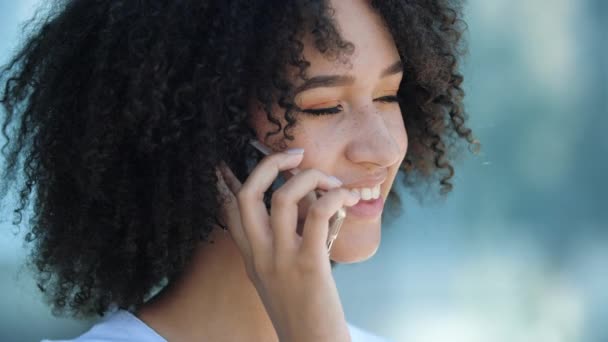 Joven atractiva mujer afroamericana hablando en el teléfono móvil al aire libre — Vídeos de Stock