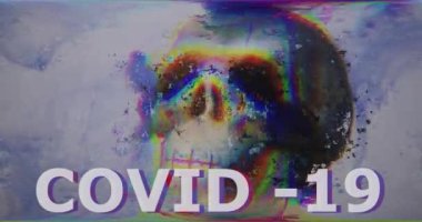 Çok renkli Covid-19 yazıtları var. Piksel arızası var. Soyut dijital efektli kafatası gürültü paraziti, bozuk televizyon. Geçmişe dönük fütürizm eski tarz. Virüs koronası ile video sinyali hasarı