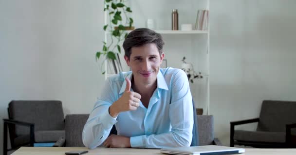 Веселый улыбающийся босс бизнесмен носит классическую рубашку, сидит за столом, показывает два больших пальца вверх, ставит, как, показывает поддержку одобрения, символ согласия, знак положительного вердикта хорошее решение, смотреть в камеру — стоковое видео