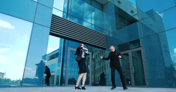 Two young student friends, couple of successful business persons, woman and man dancer dancing outdoors active movements, moving hands, celebrating success at work, friendship concept with colleagues — Stock Video
