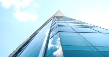 Modern fütüristik soyut işletme yüksek kule mavi cam arka plan yansıyan beyaz gökyüzü ve duvarda bulutlar ve açık mimari yapı aynalı kentsel tasarım deseni penceresi