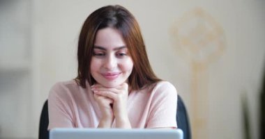 Genç kadının portresi ekran laptopuna bakıyor, iyi haberler okumaktan mutlu, e-postayla mektup alıyor, hoş bir sürpriz kutluyor, heyecan duyuyor, pozitif şoktan elleriyle yüzüne dokunuyor.