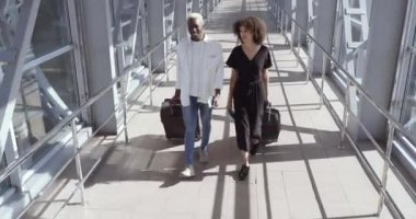 Afrikalı kadın ve Amerikalı siyahi erkek konuşarak, bavullarını taşıyarak, havaalanı terminaline ya da tren istasyonuna girerek, uçağa binmeden önce iki yolcuyla buluşarak, arkadaşlarıyla ya da evlilikleriyle seyahat ederek birlikte yürür.