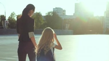 Anne ve kızı virüs salgını sırasında sokakta maske takıyor, boş şehirde yürüyor, karantinadan sonra okula geri dönüyor, solunum hastalıklarından sağlığını koruyor, el ele tutuşuyor, arkadan bakıyor.