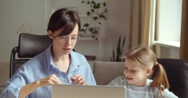 Babysitter vrouw doet huiswerk met kleine dame op laptop, zus helpt kleuter meisje te tekenen, moeder besteedt tijd met dochter achter de computer, geeft les kind thuis, quarantaine tijd elektronisch leren — Stockvideo
