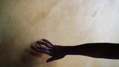 Ellerin silueti genç, başarılı, kendine güvenen kadın ressam elini yavaşça resim stüdyosundaki yeni resme yansıtarak hareket ettiriyor. Parmakları nazikçe tuvale değiyor.