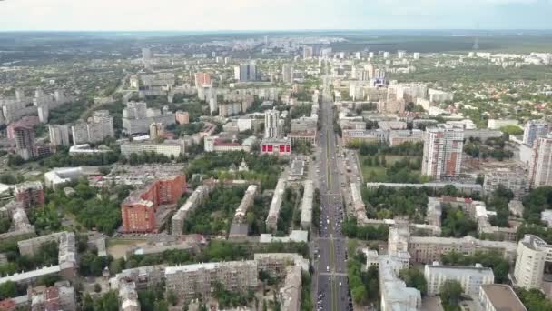 Belo tiro panorâmico largo de avenida longa, tráfego rodoviário, muitos edifícios residenciais no centro de Kharkov contra skyline na estação de primavera, a Ucrânia. Tiro aéreo de casas e telhados da cidade. — Vídeo de Stock