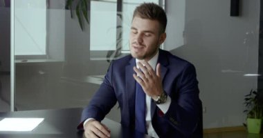 Beyaz takım elbiseli genç işadamı elinde uzaktan kumandalı web kamerası iş görüşmesi görüntülü görüşme görüntülü konuşma, video eğitimi, Webinar 'a danışmanlık,