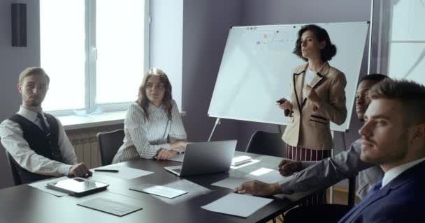 Jovem empresária lidera grupo de equipe financeira multiétnica em apresentação de reunião estratégica, trabalho no escritório. Análise de estratégia de marketing, negociação no mercado de ações ou trabalho em equipe corporativa na empresa — Vídeo de Stock