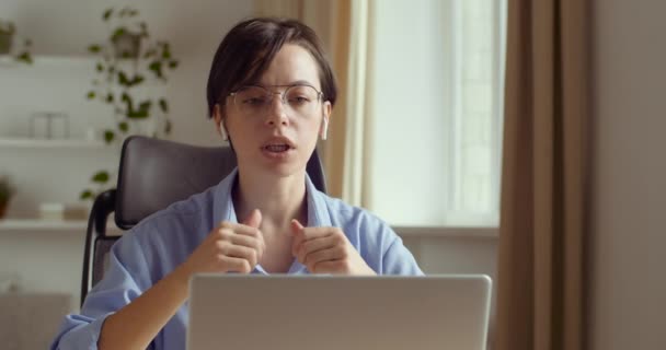 Mujer caucásica enfocada en gafas profesor de distancia tutor en línea en conferencias de auriculares en el ordenador portátil comunicarse con el estudiante por webcam videollamada chat explicar curso ayuda elearning educación informática — Vídeo de stock