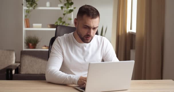 Stressed young businessman sitting at desk typing use pc, feels stress gesticulating with angry face expression, unsuccessful results of work unsaved information, lost net connection, failure concept — Stock Video