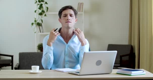 Retrato del hombre de negocios feliz sentado en la oficina o en casa en la mesa, trabajando en la computadora portátil en línea, leyendo noticias positivas, celebrando, bailando con alegría, moviendo activamente sus manos, bebiendo café aromático — Vídeos de Stock