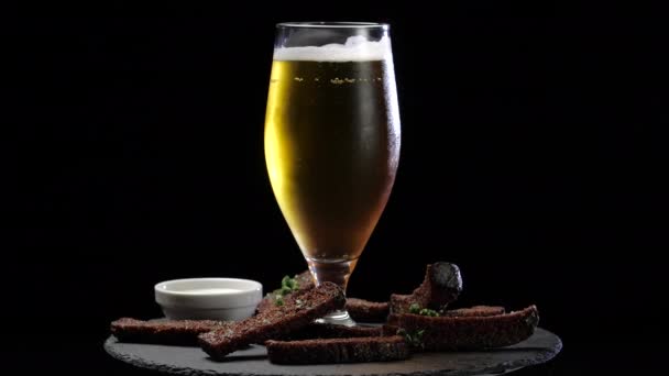 Een glas niet-alcoholisch koud fris licht of donker bier of bier staat op keukentafel in café-restaurant in de buurt van broodcroutons, weekendje weg concept, mannelijk entertainment voorbeeld — Stockvideo