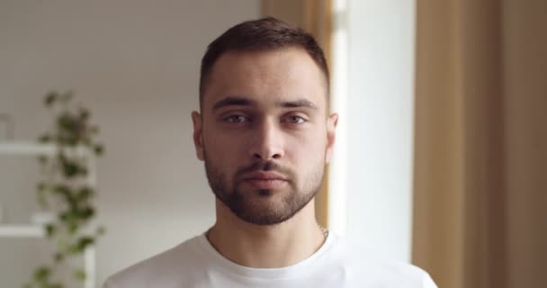 Retrato de un tipo caucásico serio milenario de pie posando ante la cámara, satisfecho estudiante hombre de negocios sonriente mirando con felicidad, sintiendo la alegría asiente de acuerdo, sacude la cabeza sí signo, primer plano — Vídeos de Stock