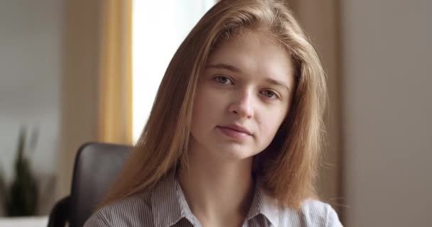 Portret zamyślonej młodej pracowniczki z ufnością patrzy w kamerę. Headshot nastolatka dziewczyna z poważnym spokojna twarz nosi bluzkę pozowanie bluzka myśli marzy siedząc w domu lub w biurze — Wideo stockowe