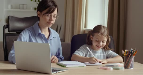 Młoda kobieta uczy dziewczyny z laptopem online w sieci, pokazuje dziecko na ekranie komputera, sprawdza zadanie, komunikuje się z młodszą siostrą, rodzina spędza razem czas, koncepcja edukacji przedszkolnej — Wideo stockowe