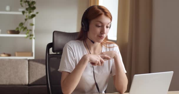 Καυκάσια γυναίκα διευθυντής φορούν ακουστικά κάθονται στο γραφείο ματιά στην ομιλία οθόνη με τον πελάτη μακρινή. Συνέντευξη εργασίας μέσω τηλεδιάσκεψης επικοινωνίας μεταξύ αιτούντος και εργοδότη. Έννοια εργασίας γραμμής βοήθειας — Αρχείο Βίντεο