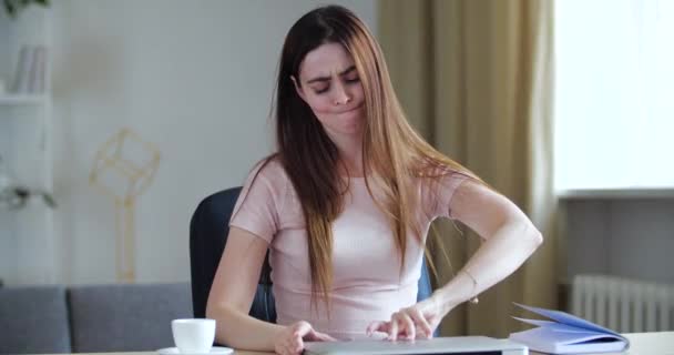 Πορτρέτο της γυναίκας freelancer κάθεται στο γραφείο στο σπίτι, ανοίγοντας το laptop με προσπάθεια, ξεκινά τη μέρα της σκληρής δουλειάς, πληκτρολογώντας στο πληκτρολόγιο, ελέγχοντας την αλληλογραφία μετά το Σαββατοκύριακο. Σοβαρή μαθήτρια που σπουδάζει online e-learning — Αρχείο Βίντεο