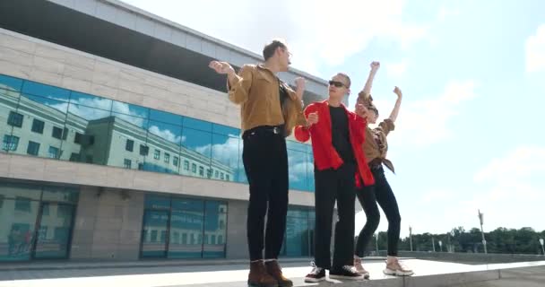 Grupo de jóvenes descansando, divirtiéndose al aire libre en el cálido clima de verano, bailando activamente juntos, celebrando fines de semana, moviendo rítmicamente las manos a la música, fiesta de modelos elegantes — Vídeos de Stock