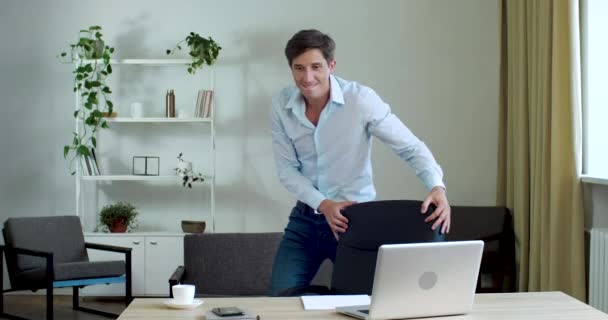 Funny active office worker freelance joker tańczący w miejscu pracy w porze lunchu, mający imprezę w domu sam, aktywnie poruszający się przed kamerą, obracający się używając krzesła jako partnera do tańca, zabawiający się — Wideo stockowe