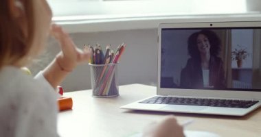 Uzaktan eğitim çevrimiçi öğrenme dersi. Ödev olarak dizüstü bilgisayar kullanan liseli bir çocuk. Çocuklar evden uzakta okuyor, öğretmendeki ekran monitörüne, koronavirüs karantinasına bakıyor.