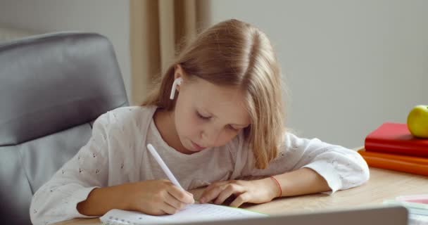 Close-up dziecko uczy się pisze w notebooku słuchanie w słuchawkach nauczyciel patrzy na ekranie laptopa robi lekcje online za pomocą nowoczesnego komputera, edukacji podczas kwarantanny i pandemii czasu wirusa korony — Wideo stockowe