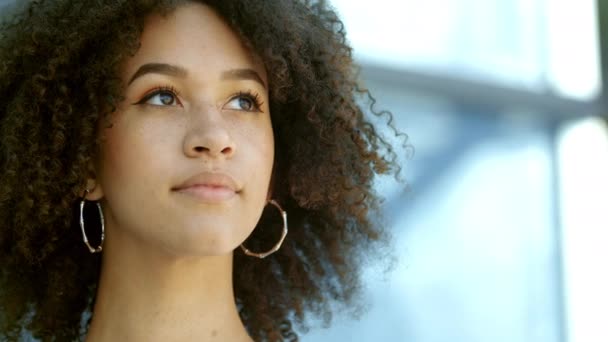 Schöne junge afroamerikanische Mädchen blickt auf und in die Kamera. Portrait stilvolle Frau, selbstbewusste Studentin mit lockiger Frisur, Sommersprossen. Dame im urbanen Stadthintergrund. Serie von echten Menschen — Stockvideo